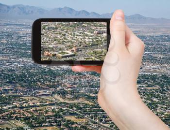 travel concept - tourist taking photo of residential area of Las Vegas on mobile gadget, USA