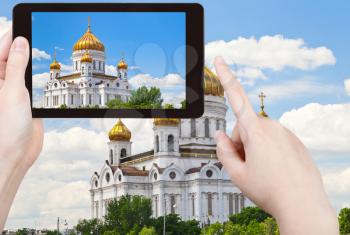 travel concept - tourist taking photo of Cathedral of Christ the Saviour, Moscow on mobile gadget, Russia