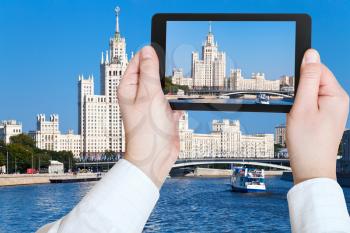 travel concept - tourist taking photo of Moscow cityscape with Stalin's high-rise building on kotelnicheskaya embankment on mobile gadget, Russia