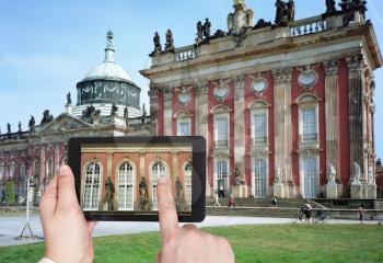 travel concept - tourist taking photo of statues of New Palace in Sanssouci Royal Park, Potsdam on mobile gadget, Germany