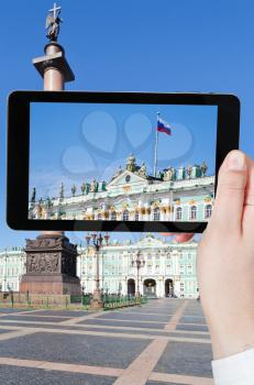 travel concept - tourist taking photo of Russian state flag on Palace Square, St.Petersburg, Russia on mobile gadget