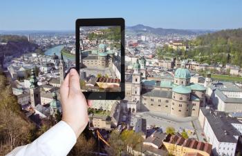 travel concept - tourist taking photo of Salzburg panorama from the Hohensalzburg Castle on mobile gadget