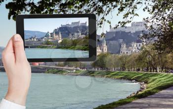 travel concept - tourist taking photo of Salzach River and Salzburg city on mobile gadget, Austria