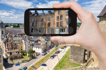 travel concept - tourist taking photo of Sedan town on mobile gadget, France