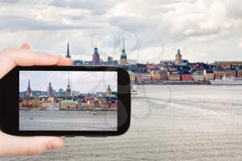 travel concept - tourist taking photo panorama of Stockholm city in autumn day, Sweden on mobile gadget