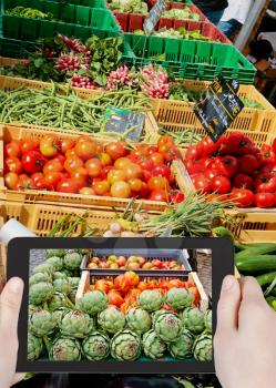 travel concept - tourist taking photo of street vegetable market in France on mobile gadget