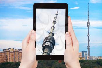 travel concept - tourist takes picture of Ostankino television tower in Moscow on smartphone,