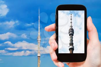 travel concept - tourist takes picture of Ostankinskaya TV tower in Moscow on smartphone,