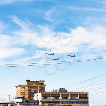 military aircrafts flight in blue sky over urban house