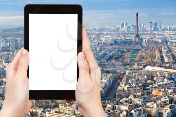 travel concept - tourist photographs Paris cityscape with Eiffel Tower afternoon on tablet pc with cut out screen with blank place for advertising logo