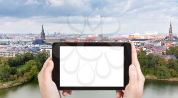 travel concept - tourist photograph panorama of Copenhagen city, Denmark on tablet pc with cut out screen with blank place for advertising logo