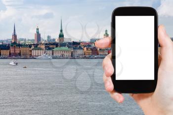 travel concept - tourist photograph skyline of Stockholm city , Sweden in autumn on smartphone with cut out screen with blank place for advertising logo