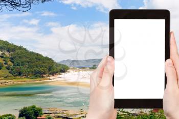 travel concept - tourist photograph Cies Islands (illas cies) - Galicia National Park in Atlantic Ocean, Spain on tablet pc with cut out screen with blank place for advertising logo