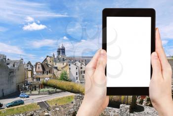 travel concept - tourist photograph town Sedan from castle wall, France in summer day on tablet pc with cut out screen with blank place for advertising logo