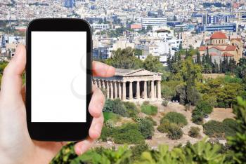 travel concept - tourist photograph Temple of Hephaestus and Athens city view from Acropolis hill, Greece on smartphone with cut out screen with blank place for advertising logo