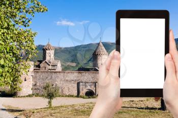 travel concept - tourist photograph Tatev Monastery in Armenia on tablet pc with cut out screen with blank place for advertising logo