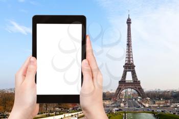 travel concept - tourist photograph eiffel tower from Trocadero in Paris on tablet pc with cut out screen with blank place for advertising logo