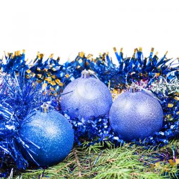 blue Christmas balls on green fir tree branch isolated on white background