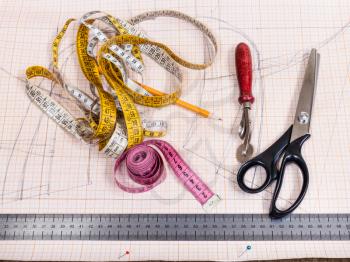 dressmaking still life - top view of cutting table with pattern and tailoring tools