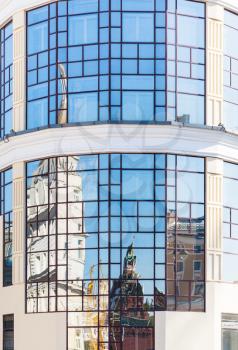 historic Moscow Kremlin tower reflected in mirrow windows of modern building