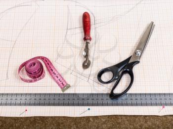 dressmaking still life - top view of cutting table with textile, pattern, tailoring tools