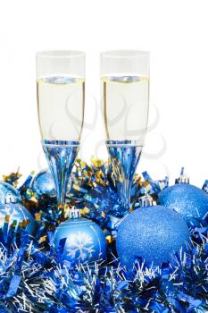 two glasses of sparkling wine at blue Christmas decorations isolated on white background