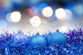 Xmas still life - blue balls, tinsel with soft blue Christmas lights bokeh background
