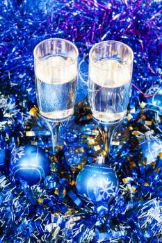 Christmas still life - above view of two glasses of sparkling wine in blue Xmas balls and tinsel