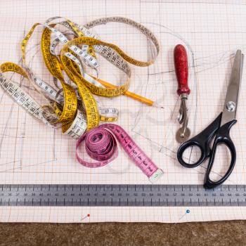 dressmaking still life - top view of cutting table with cloth, pen, pattern, tailoring tools