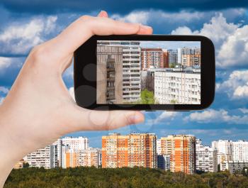 travel concept - tourist photographs picture of apartment houses on smartphone