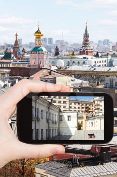 travel concept - tourist photographs picture of old Moscow urban yard on smartphone,