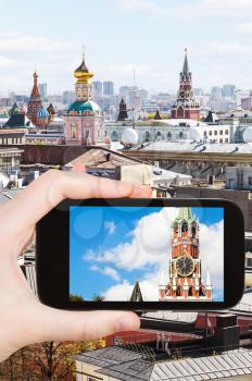 travel concept - tourist photographs picture of tower in Moscow on smartphone