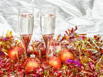 Christmas still life - Two glasses of champagne with golden Xmas decorations on gold background