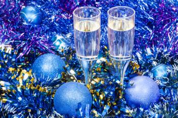 Christmas still life - two glasses of champagne in blue Xmas balls and tinsel