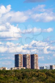 blue sky with white clouds over apartment buildings in summer