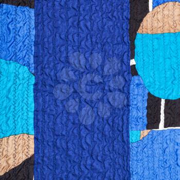 textile background from stitched wrinkled blue silk fabric and patchwork