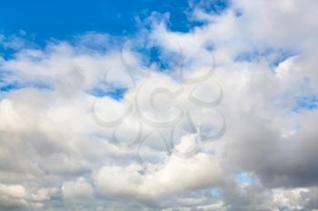 natural background - low gray and white autumn clouds in blue sky on windy day