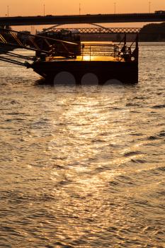 travel to Bratislava city - SNP bridge and jetty on Danube river at yellow dawn