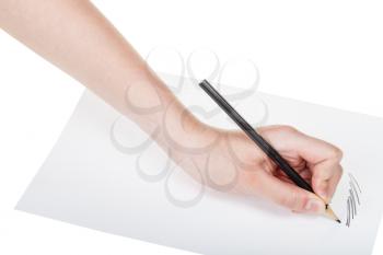 hand draws by wooden black pencil on sheet of paper isolated on white background