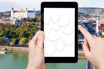 travel concept - tourist photographs Castle and Bratislava old town on tablet pc with cut out screen with blank place for advertising logo