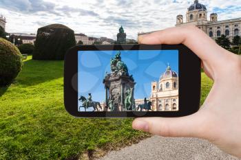 travel concept - tourist snapshot of Empress Maria Theresa statue on Maria Theresien square in Vienna on smartphone