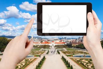 travel concept - tourist photographs garden of Belvedere Palace in Vienna on tablet pc with cut out screen with blank place for advertising logo