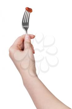 hand holding dinning fork with impaled one brown bean isolated on white background