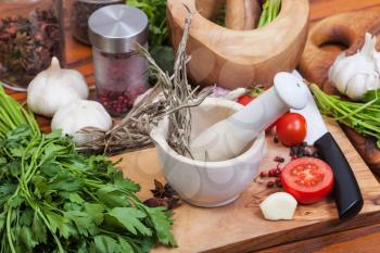 cooking seasonings - pestle grass in ceramic mortar and spices on table