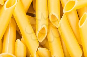 food background - durum wheat semolina pasta penne lisce close up