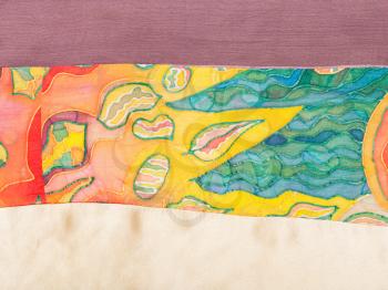 textile background - strip of patchwork fabric with painted silk batik