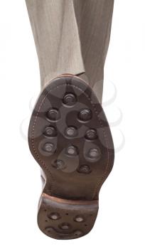 front view of male left foot in brown shoe takes a step isolated on white background