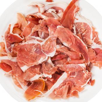 top view of thin sliced dry-cured ham on white plate isolated on white background