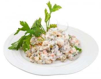 olivier russian salad with mayonnaise decorated with green parsley on white plate isolated on white background