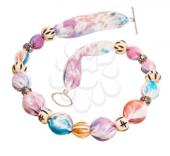 top view of textile necklace from pink silk batik, glass and bone beads isolated on white background